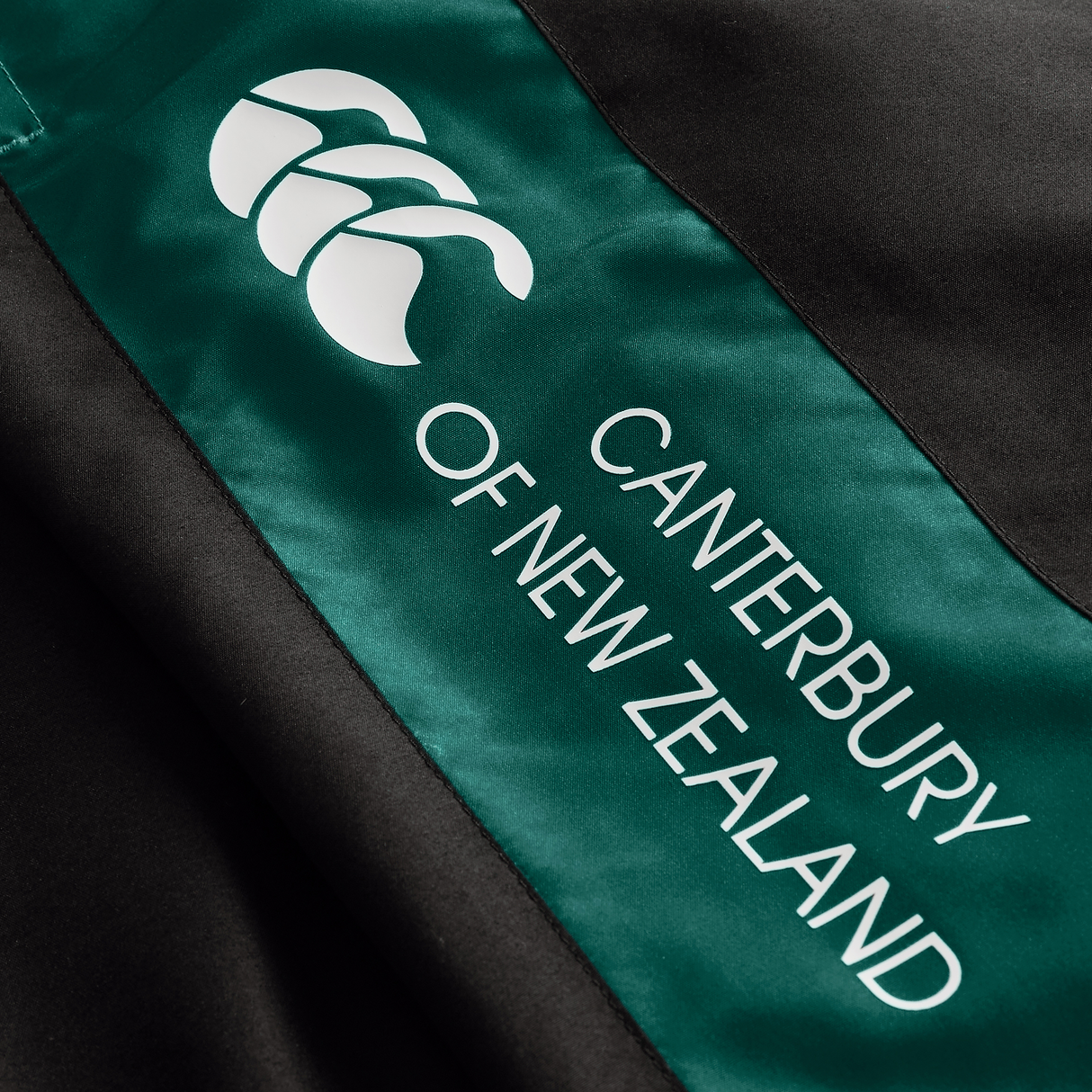 Close-up of green and black Ireland Legends Track Pant by Canterbury, featuring the brand’s white logo and text.
