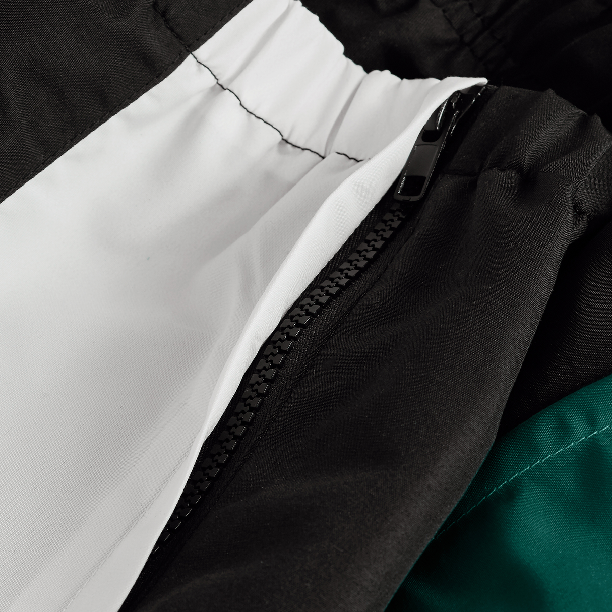 Close-up of the Ireland Legends Track Pant by Canterbury, showcasing a visible zipper, white lining, and green fabric section.