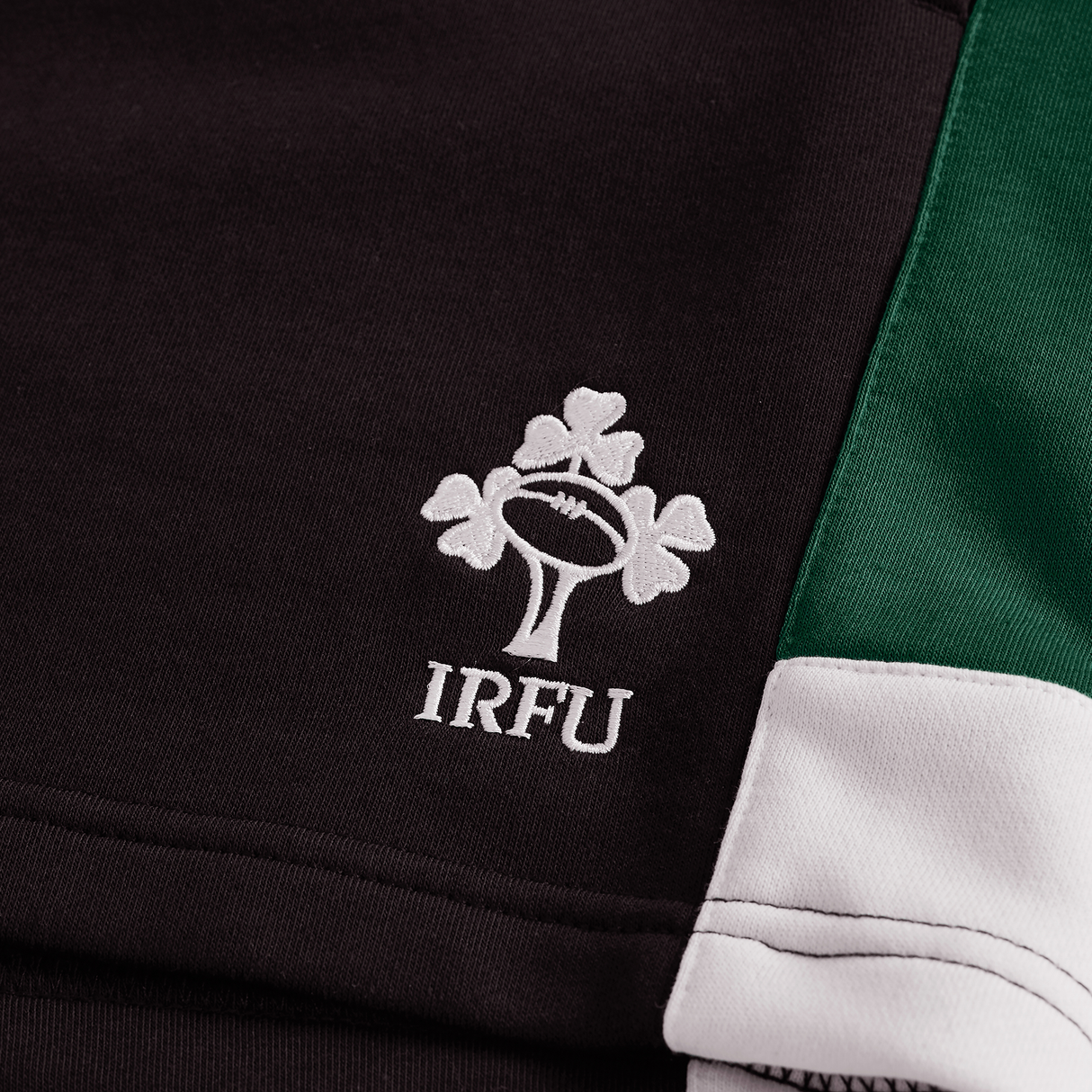 Close-up of black, green, and white Ireland Legends 7" Shorts by Canterbury, featuring the embroidered Irish Rugby Football Union (IRFU) logo with a shamrock and rugby ball design.