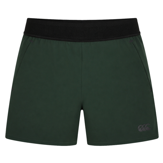 Canterbury Everest Woven Short 5" in dark green features a black elastic waistband, side pockets, and four-way stretch fabric for comfort and mobility, shown on a plain white background.