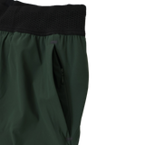 Close-up of the Canterbury Everest Woven Short 5" by Canterbury, a green training short with black elastic waistband, zippered side pocket, and four-way stretch fabric for optimal comfort.