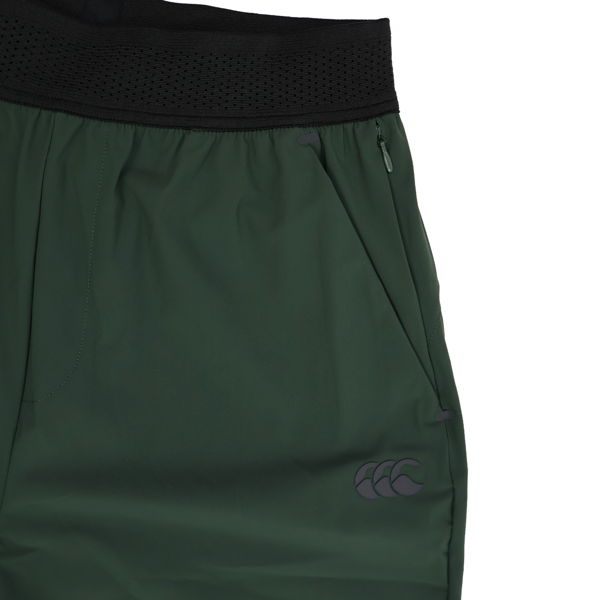 Close-up of the Canterbury Everest Woven Pant 30" by Canterbury, featuring a black waistband, zippered pocket, small logo on the lower leg, and crafted from four-way stretch fabric for comfort and flexibility.