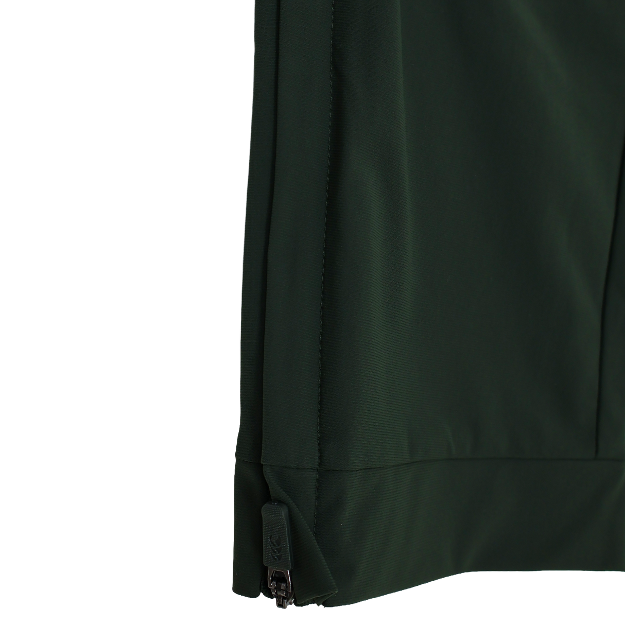 Close-up of the lower edge of a dark green Canterbury Everest Woven Pant 30" by Canterbury, highlighting the black zipper along the side seam and four-way stretch fabric, set against a white background.