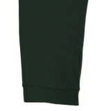 Close-up of the Canterbury Everest Woven Pant 30" in dark green by Canterbury, showing its cuffed hem and four-way stretch fabric, set against a plain white background.