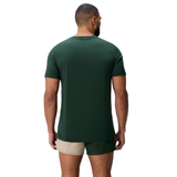 A man faces away wearing a Canterbury FUN. T-SHIRT AM in dark green and beige shorts with green trim, set against a plain white background.