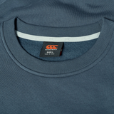 Close-up of a blue Canterbury EVERYDAY GFX CREW SWEATER laid flat, highlighting the collar and black size L label with orange logo and text—ideal for everyday wear.