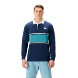 A man wearing a Canterbury Stripe Rugby Jersey by Canterbury, featuring navy blue with white and teal stripes and a white collar, paired with light blue shorts, stands facing forward against a white background.
