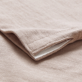 Close-up of a beige knit fabric with a folded corner, revealing its texture and inner white lining, similar to the quality found in Canterbury's Stripe Rugby jersey.