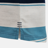 Close-up of the Canterbury Yarn Stripe Polo by Canterbury, showing its blue and white striped fabric, a small side slit, and three navy stitches above the hem for classic rugby styling.