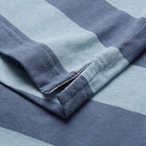 Close-up of the hem and side split on a Canterbury Yarn Stripe Polo by Canterbury, featuring blue and light blue striped fabric with detailed stitching and texture that emphasize its classic rugby-inspired style.