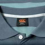 Close-up of the Canterbury Yarn Stripe Polo in blue and teal, showcasing classic rugby style details with a Canterbury brand label marked size L and Made in China under the collar.