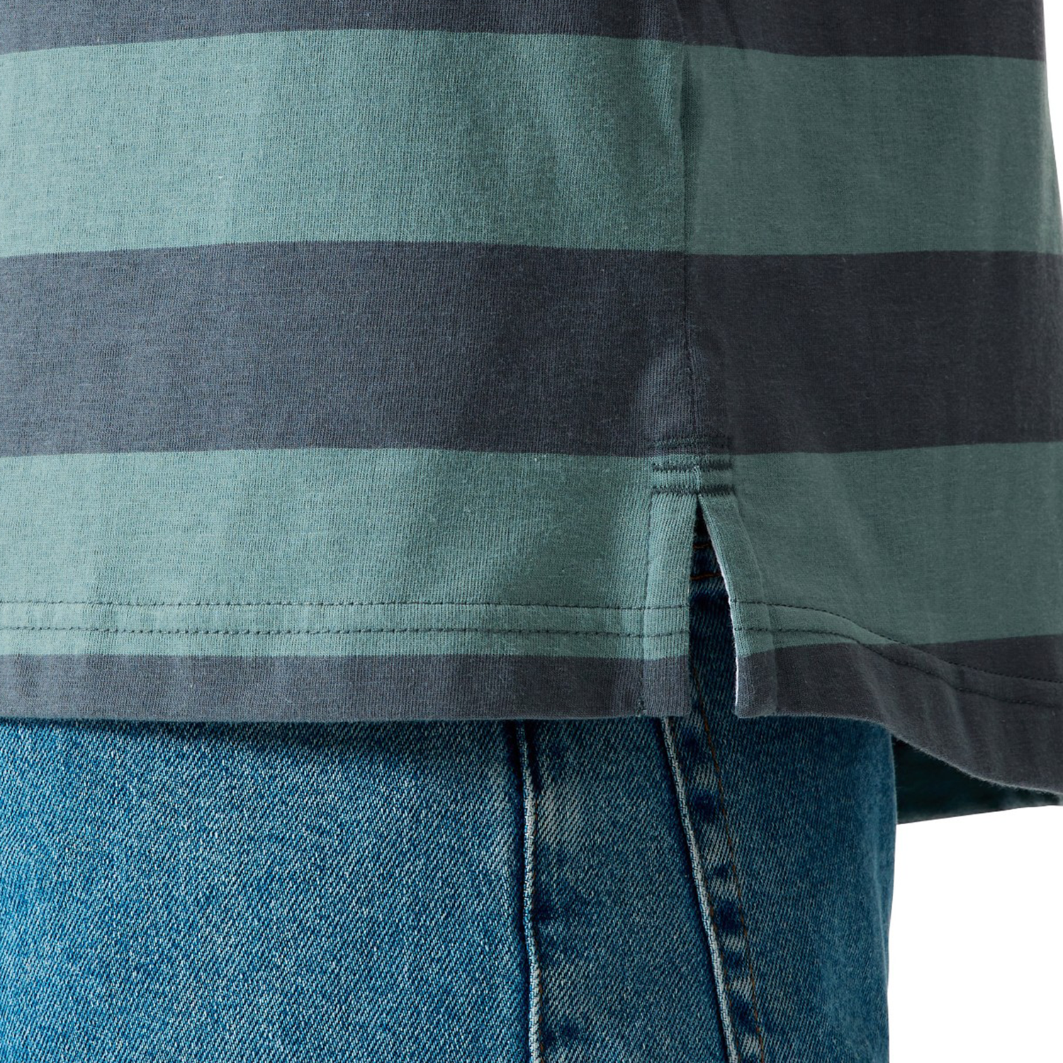 Close-up of the Canterbury Yarn Stripe Polo by Canterbury in green and dark gray, featuring a side slit, styled over blue denim jeans for a classic rugby look.