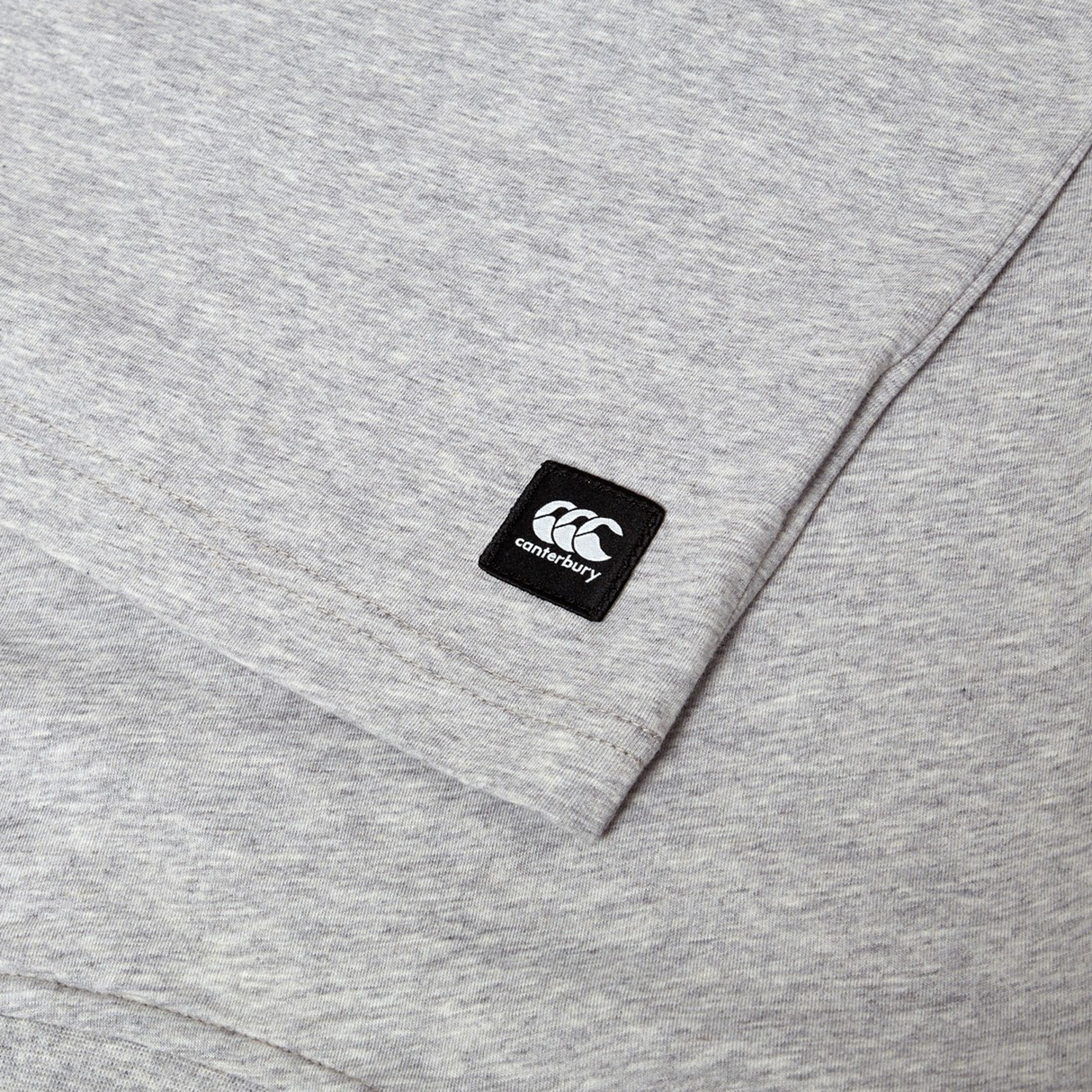 Close-up of the Canterbury Uglies Logo T-shirt, a grey cotton blend tee featuring a small black Canterbury logo patch sewn near the sleeve.