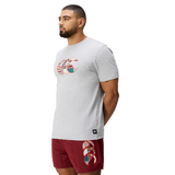 A man faces left, wearing a light gray Canterbury Uglies Logo T-shirt and red shorts with a matching graphic design, set against a plain white background.