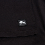Close-up of the Canterbury Uglies Logo T-shirt in a black cotton blend, featuring a stitched rectangular Canterbury logo patch near the hem, inspired by classic Canterbury rugby shirts.