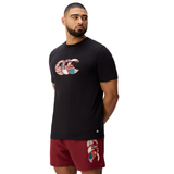 A man stands against a white background wearing Canterbury's Uglies Logo T-shirt in black cotton blend and matching maroon shorts, both featuring the distinctive Canterbury Uglies Logo design.