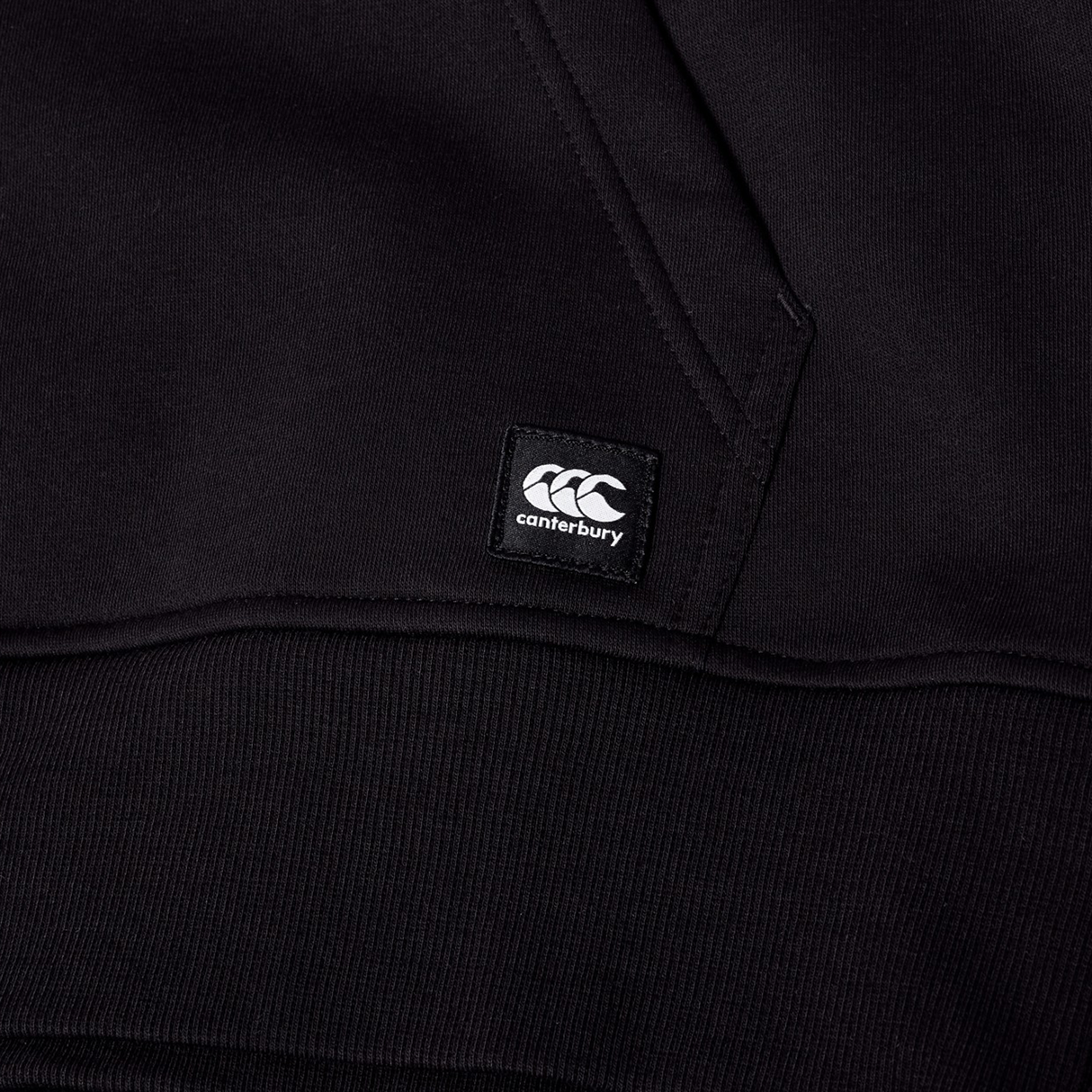 Close-up of the Canterbury Uglies Logo Hoodie in black, highlighting a stitched Canterbury brand tag and visible seam details.