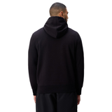 A man in a black Canterbury Uglies Logo Hoodie and black pants stands with his back to the camera against a white background.