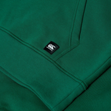 Close-up of the Canterbury Uglies Logo Hoodie in green, featuring ribbed cuffs and a small black and white Canterbury logo tag.