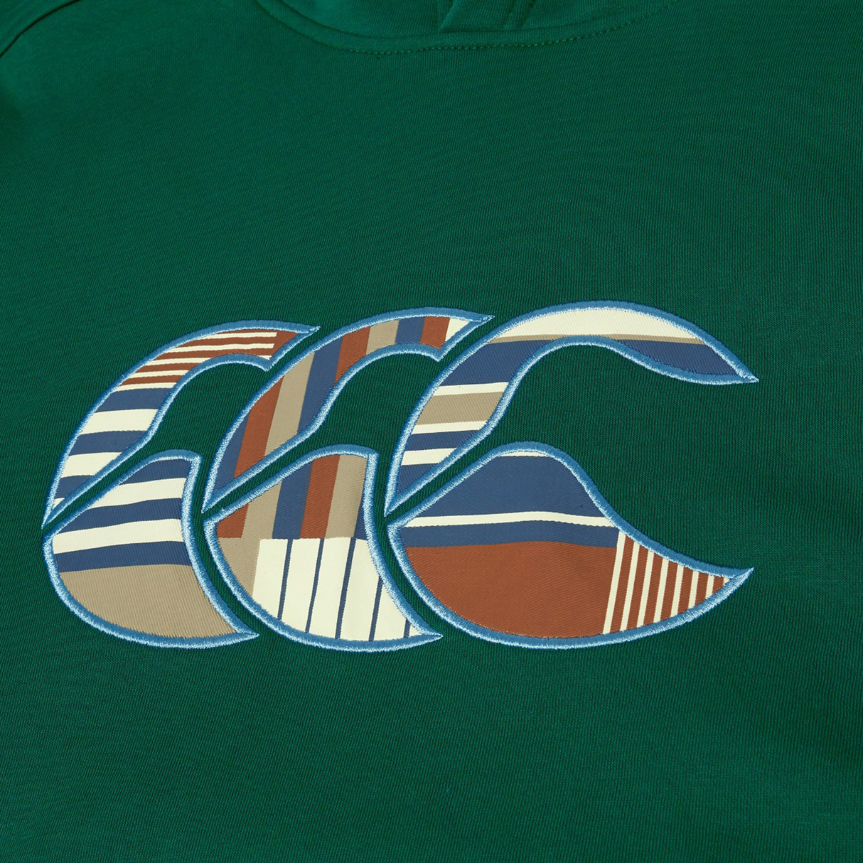 The Canterbury Uglies Logo Hoodie by Canterbury is a green rugby hoodie featuring a large "CCC" logo in blue, brown, white, and tan geometric patterns.