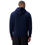 A person in a navy blue Canterbury Uglies Logo Hoodie and black pants stands with their back to the camera against a white background.