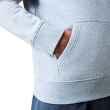 A person wearing a light gray Canterbury Uglies Logo Hoodie with their right hand in the front pocket, shown from the waist to mid-arm.