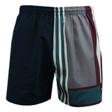 The Canterbury Uglies Harletic Short by Canterbury features an athletic poly short style with an elastic waistband and a split design—solid navy on one side, and teal, gray, white, and burgundy stripes on the other for a sporty look.