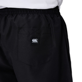 Close-up of a person wearing black Canterbury Uglies 5" Tactic Shorts featuring an elastic waistband, back pocket, and the Canterbury logo.