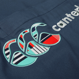 Close-up of a dark blue Uglies 32" Stadium Pant by Canterbury, featuring the embroidered Canterbury logo with geometric patterns and the partially visible word "canterbury.