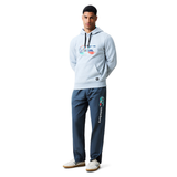 A man faces forward in a light gray Canterbury hoodie with a colorful graphic and dark gray Uglies 32" Stadium Pant by Canterbury, both ideal for rugby fans, paired with white sneakers.