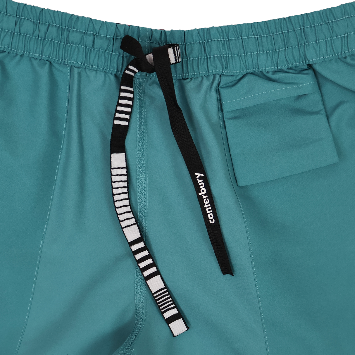 Close-up of Canterbury Women's Canterbury Uglies Tactic Short in teal, featuring an elastic waistband, black and white striped drawstring, and a small right-side pocket.