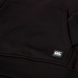 Close-up of a black Canterbury Youth Uglies Logo Hoodie showing a front pocket, ribbed hem, and a small stitched Canterbury brand label, capturing the classic rugby style.