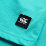 Close-up of the Youth Canterbury Uglies Logo T-shirt in turquoise, featuring a black rectangular Canterbury logo patch sewn onto the fabric.