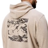 A person wearing the Canterbury FORCE HOODIE in beige, featuring a large abstract graphic and stylized "CCC" logo on the back.
