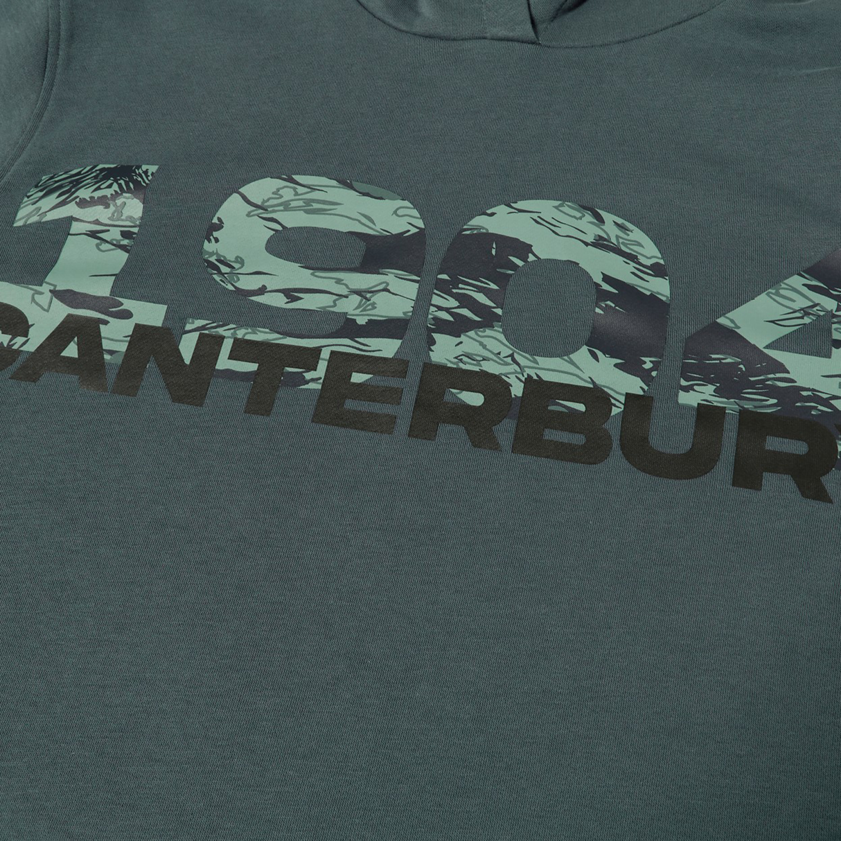 A teal shirt featuring "1904" in a green camo pattern and "CANTERBURY" in bold black below, perfect to pair with your Canterbury FORCE HOODIE.