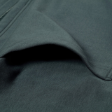 Close-up of Canterbury's FORCE HOODIE in dark green, highlighting the side pocket and visible seam stitching.