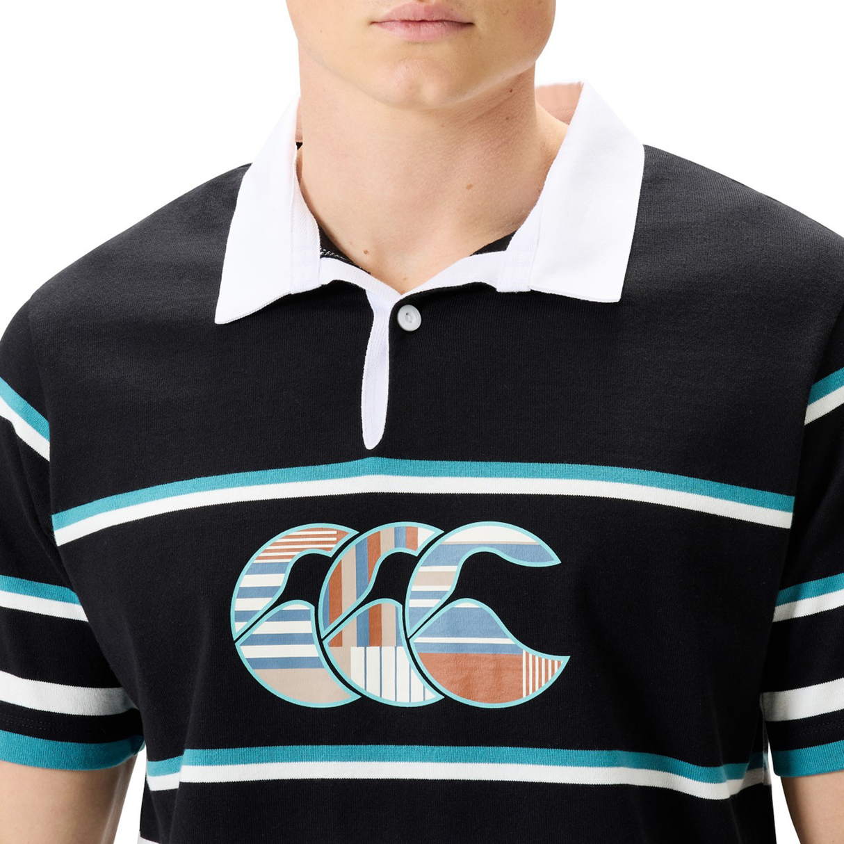 A person wearing a Canterbury Uglies Short Sleeve Classic Rugby Jersey by Canterbury, featuring black and white with teal and white horizontal stripes and a stylized logo on the chest.
