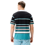 A man with short hair, shown from the back, wears a Canterbury Uglies Short Sleeve Classic Rugby Jersey—a black, teal, and white heavyweight cotton shirt by Canterbury—and light blue jeans.