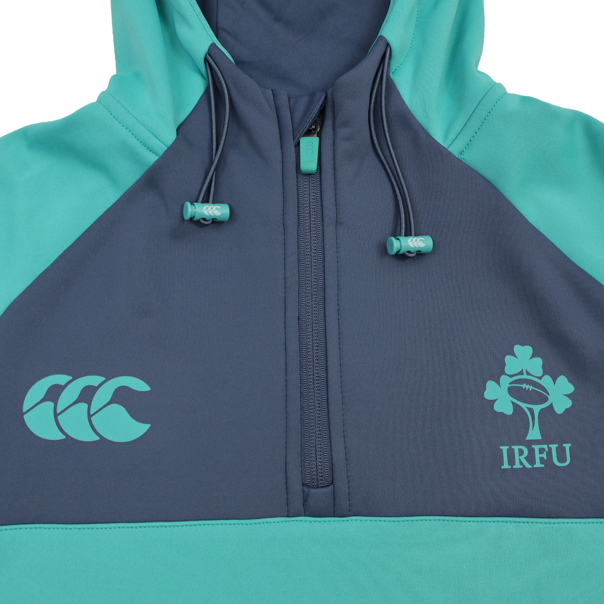 The Ireland 26/27 Summer Tour Training Hoodie by Canterbury features a teal and navy design, quarter zip, moisture-wicking fabric, and IRFU and Canterbury logos—ideal for fans of the Ireland Summer Tour.