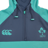 The Ireland 26/27 Summer Tour Training Hoodie by Canterbury features a teal and navy design, quarter zip, moisture-wicking fabric, and IRFU and Canterbury logos—ideal for fans of the Ireland Summer Tour.