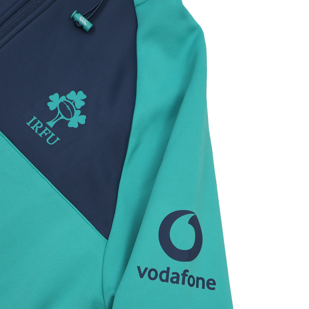 Close-up of the Ireland 26/27 Summer Tour Training Hoodie by Canterbury in teal and navy, showing the IRFU chest logo and Vodafone sleeve logo. This moisture-wicking Canterbury hoodie is built for high-performance training.