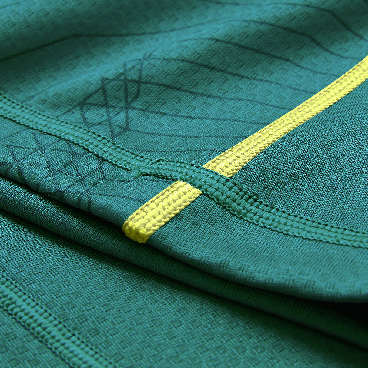 Close-up of green fabric with visible stitching and a yellow stripe detail, highlighting the texture and seam patterns characteristic of the Ireland 26 Home Test Jersey by Canterbury.