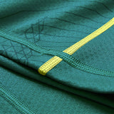 Close-up of green fabric with visible stitching and a yellow stripe detail, highlighting the texture and seam patterns characteristic of the Ireland 26 Home Test Jersey by Canterbury.