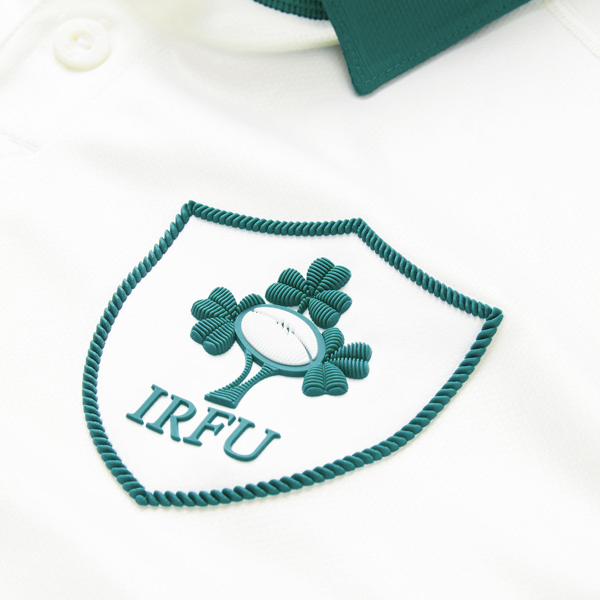 Close-up of the Ireland 26 Alternate Pro Jersey by Canterbury in white, featuring the IRFU logo—a rugby ball and shamrock within a green-trimmed shield.