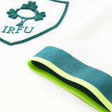 Close-up of the white fabric from the Ireland 26 Alternate Pro Jersey by Canterbury, featuring an IRFU logo patch and a sleeve with green, teal, and yellow stripes.
