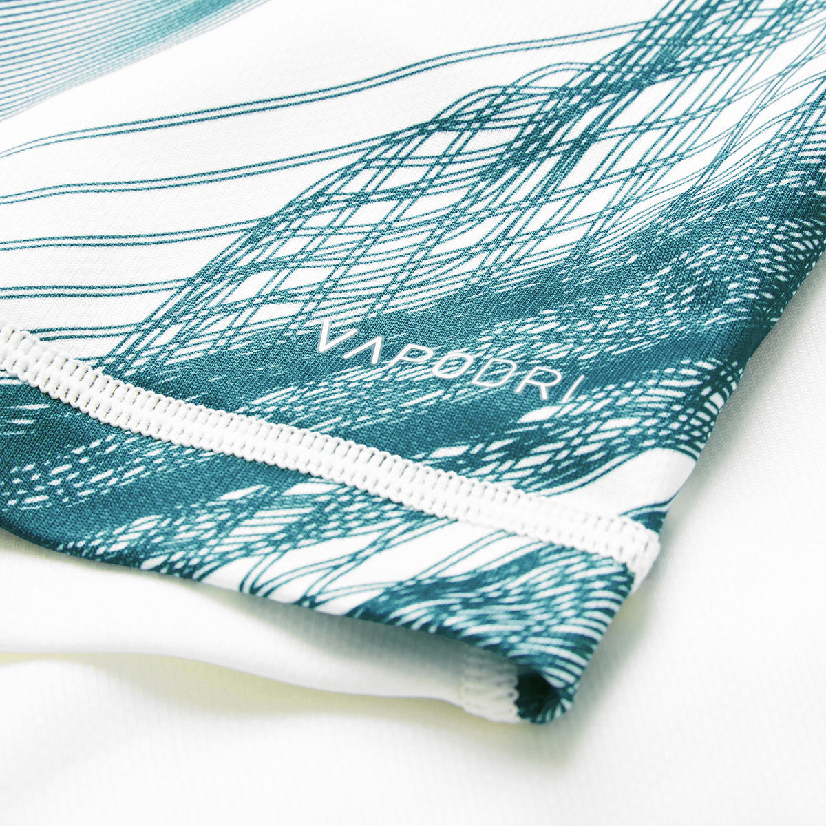 Close-up of white fabric with green abstract lines and the word “VAPODRI” printed near the stitched edge, highlighting the premium detailing of the Ireland 26 Alternate Pro Jersey by Canterbury.