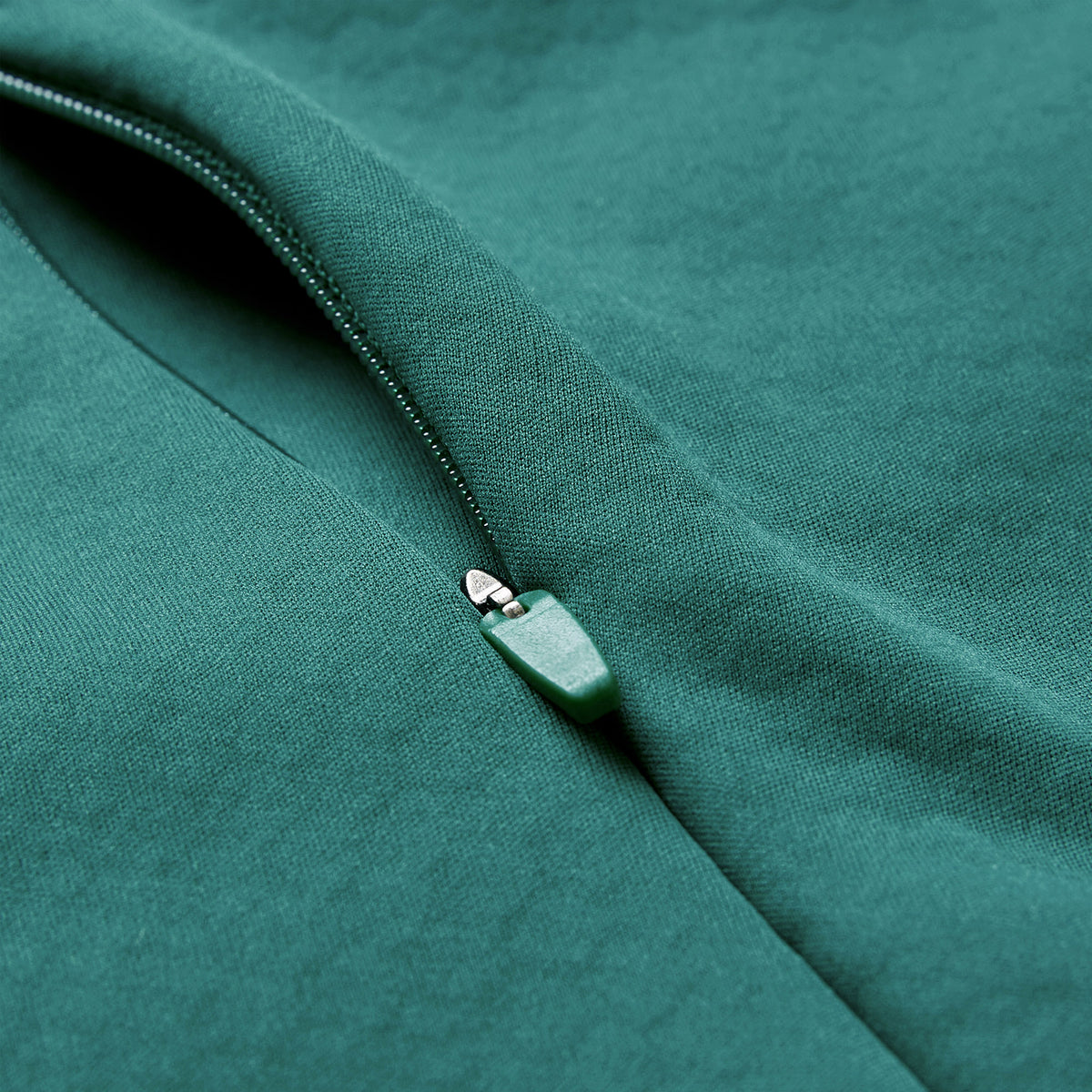 Close-up of a partially unzipped green zipper on a matching green fabric garment, showcasing the distinctive design of the Ireland 26 1/4 Zip Training Top by Canterbury, featuring advanced Thermoreg technology.