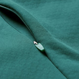 Close-up of a partially unzipped green zipper on a matching green fabric garment, showcasing the distinctive design of the Ireland 26 1/4 Zip Training Top by Canterbury, featuring advanced Thermoreg technology.