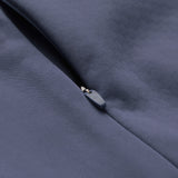 Close-up of the Canterbury Ireland 26 1/4 Zip Training Top in gray, partially zipped on a smooth fabric surface, highlighting the zipper pull and stitching details. This training top is equipped with Canterbury’s advanced Thermoreg technology for superior comfort.