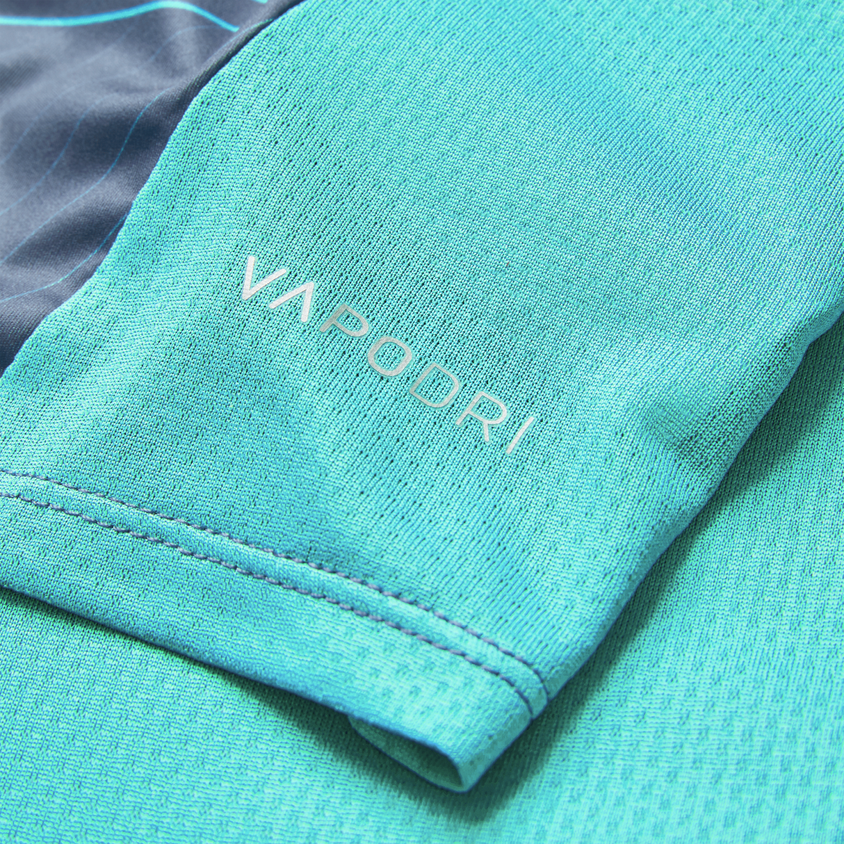 Close-up of a blue Ireland 26/27 Summer Tour Superlight Training Tee sleeve by Canterbury, showcasing the white "VAPODRI" logo.